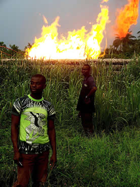 photo of two serious looking men with a fire in a field behind them